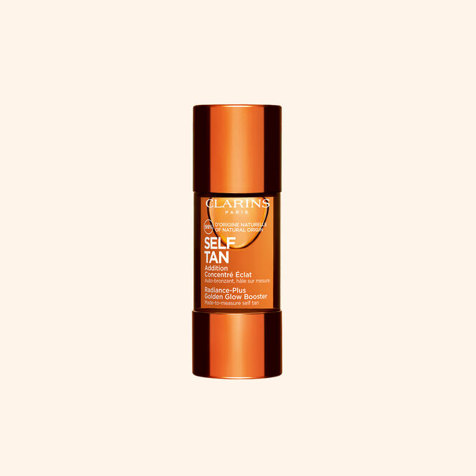 Embalagem de autobronzeador impulsionador da luminosidade Clarins apresentado sobre um fundo bege para uma rotina de cuidado da pele radiante e bronzeada.