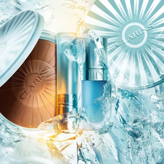 Imagem da cole&ccedil;&atilde;o de ver&atilde;o Clarins em gelo: p&oacute; bronzeador, &oacute;leo labial criog&eacute;nico e b&aacute;lsamo labial refrescante, destacando os produtos essenciais para o ver&atilde;o.