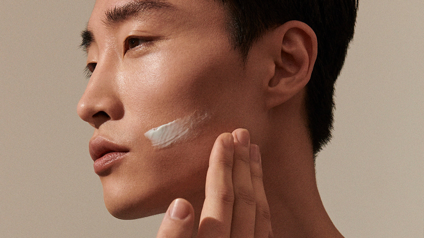 Man examining her face in the mirror